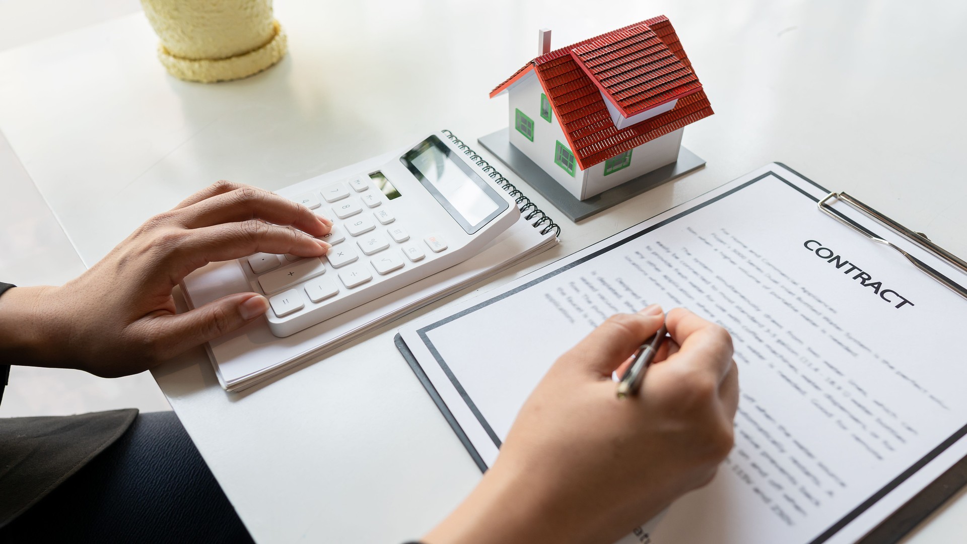 Real estate agents work in the office with paperwork. and offer a house plan for customers to buy and buy with insurance